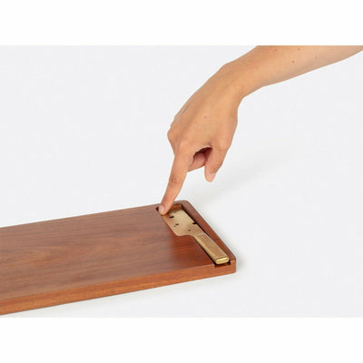 Finger pointing to Wooden long cheese board with knife