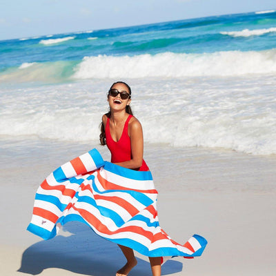 girl at beach with red and blue striped towel