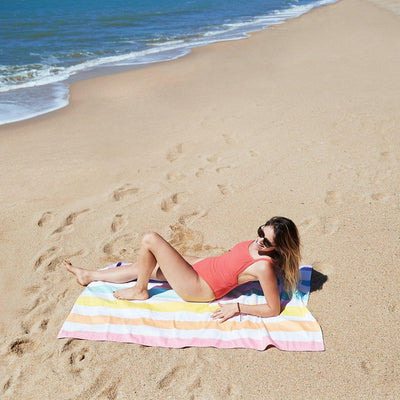 woman laying on quick dry towel at the beach